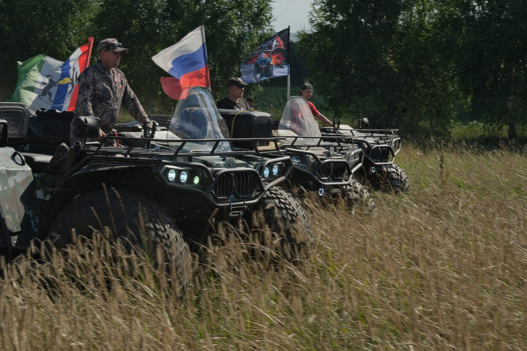 Колонна квадроциклов Авангард с флагами в поле